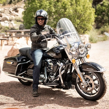 A rider wearing a bluetooth cruiser helmet on a Harley-Davidson bike