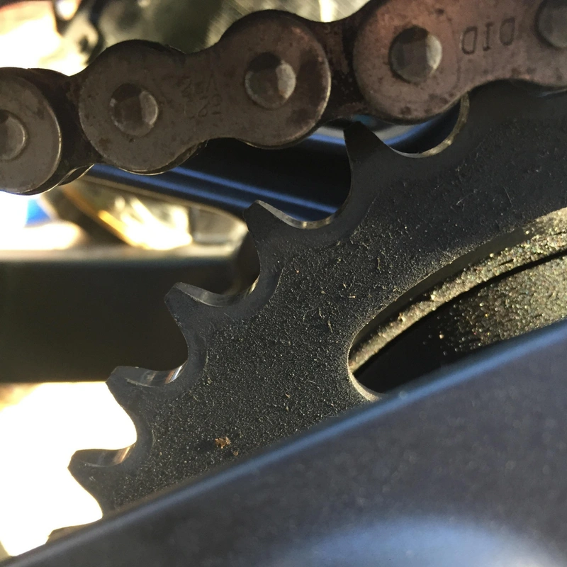 A dirty chain and rear sprocket of a motorcycle