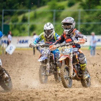 Image of kids riding electric dirt bike on sports ground