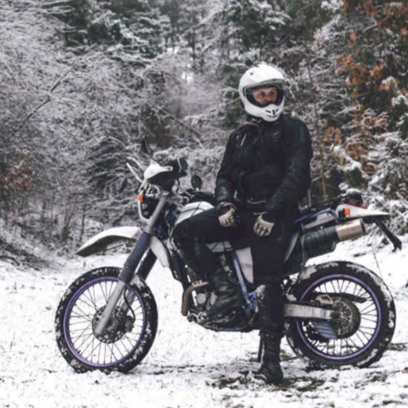 Image of a biker wearing protective winter riding gear while riding in snow and ice