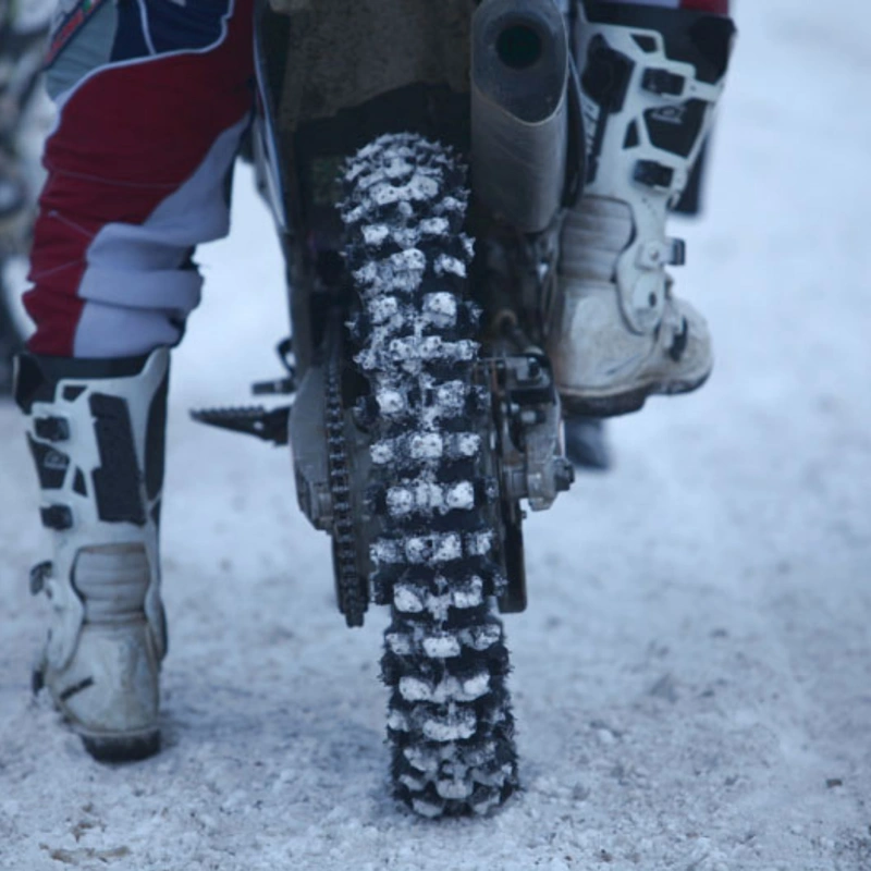 Image of a rear motorcycle tire ladded with ice in winters
