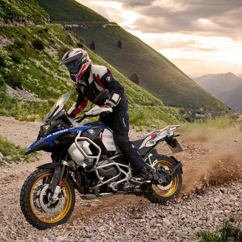 Image of a motorcyclist turning BMW R1250 on a gravel road