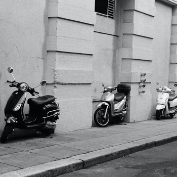 Three air-cooled scooters parked on the street